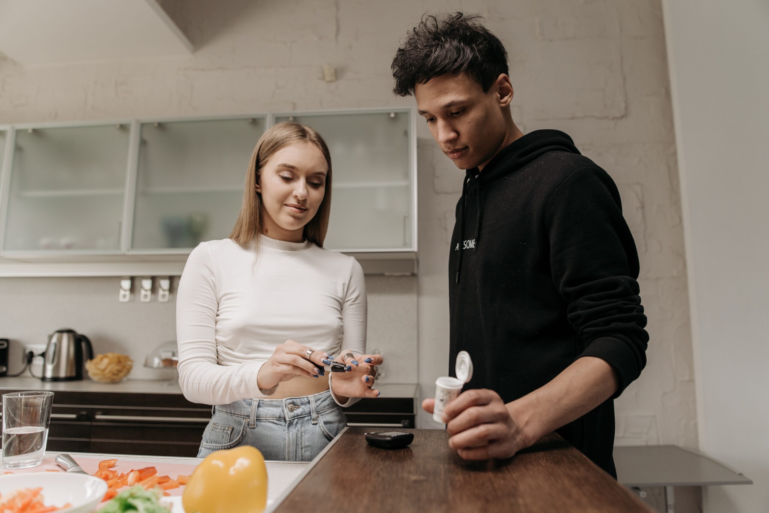 A woman talking to a man about her diabetes while in the kitchen.