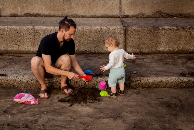 a dad playing with his daughter outside