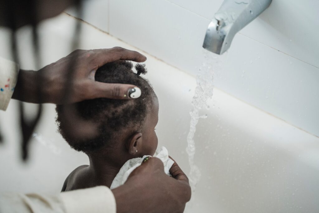 A person bathing a child as part of the bedtime routine.