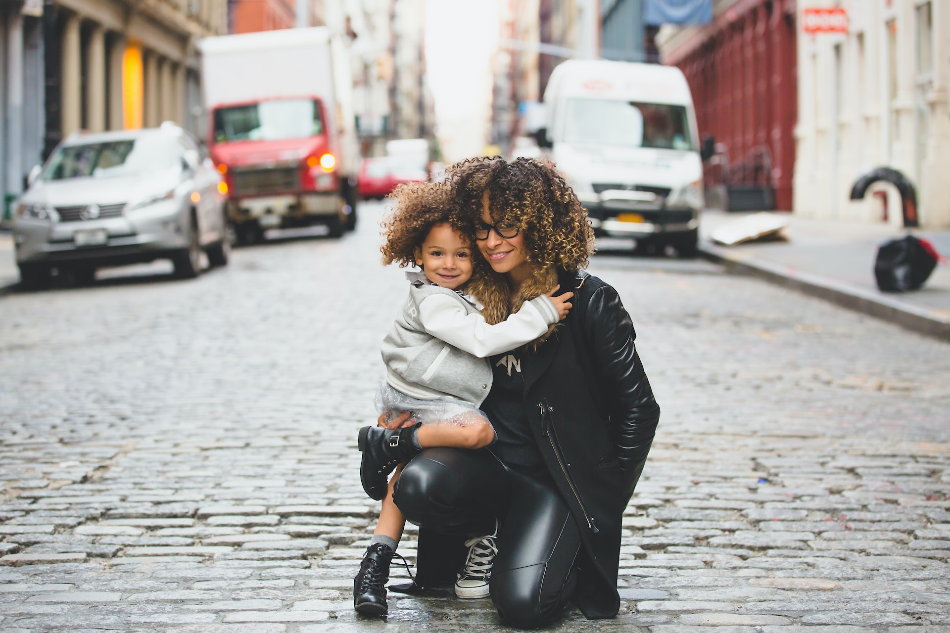 Woman hugging her child in the middle of a quiet street