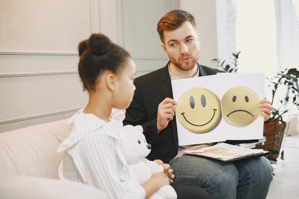 Child talking to a therapist about what she sees in the picture that the therapist is holding