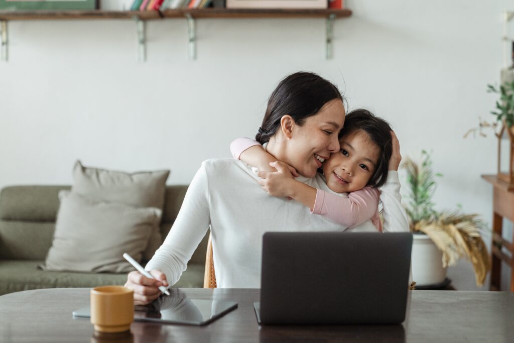 Little girl hugging her mom who is researching how to find diverse and inclusive books for your kids