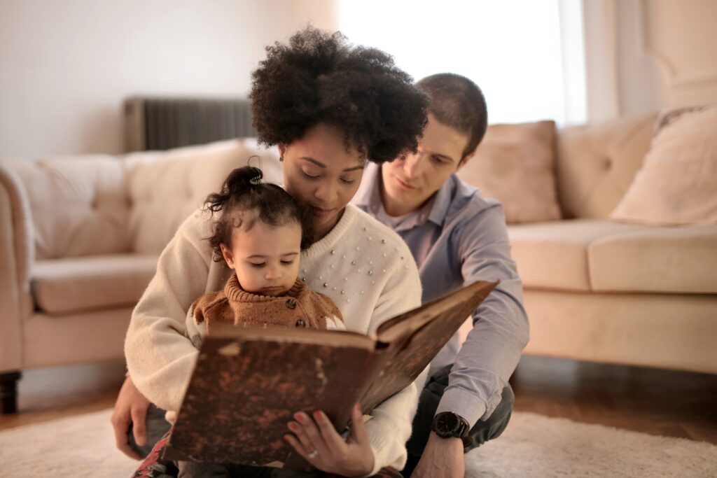Parents reading a book with their two children.