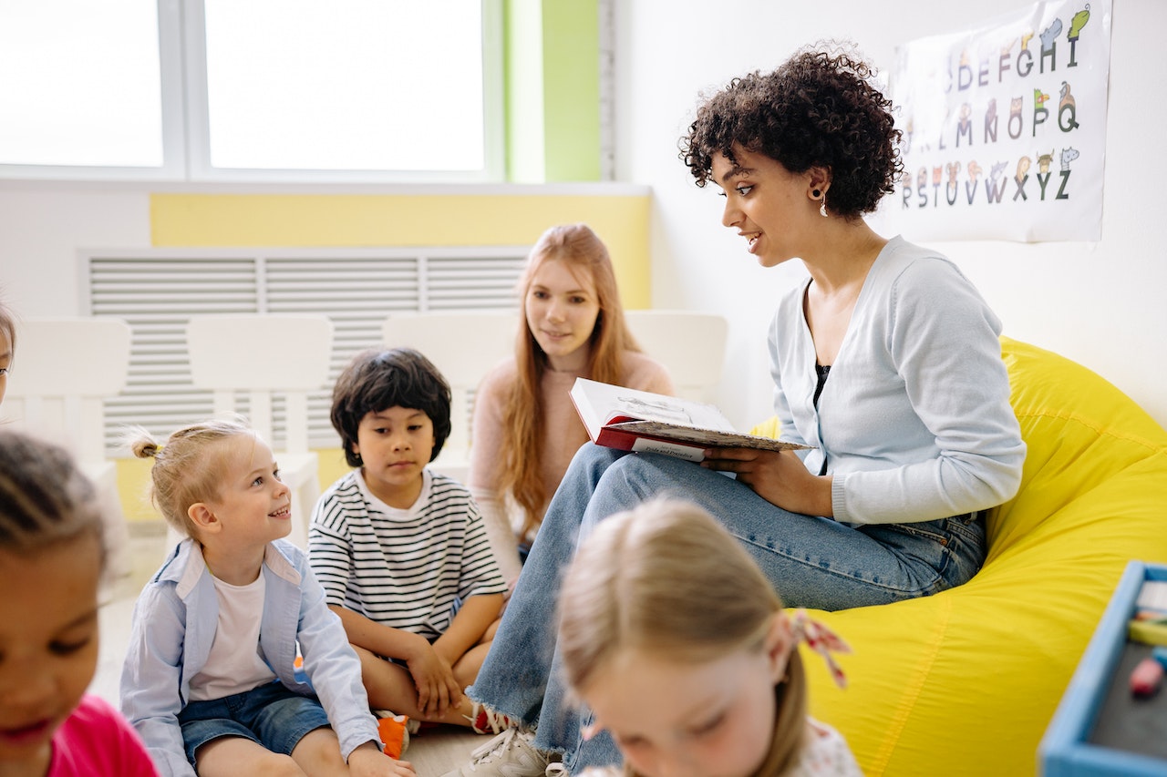 A woman reading to children in a classroom.