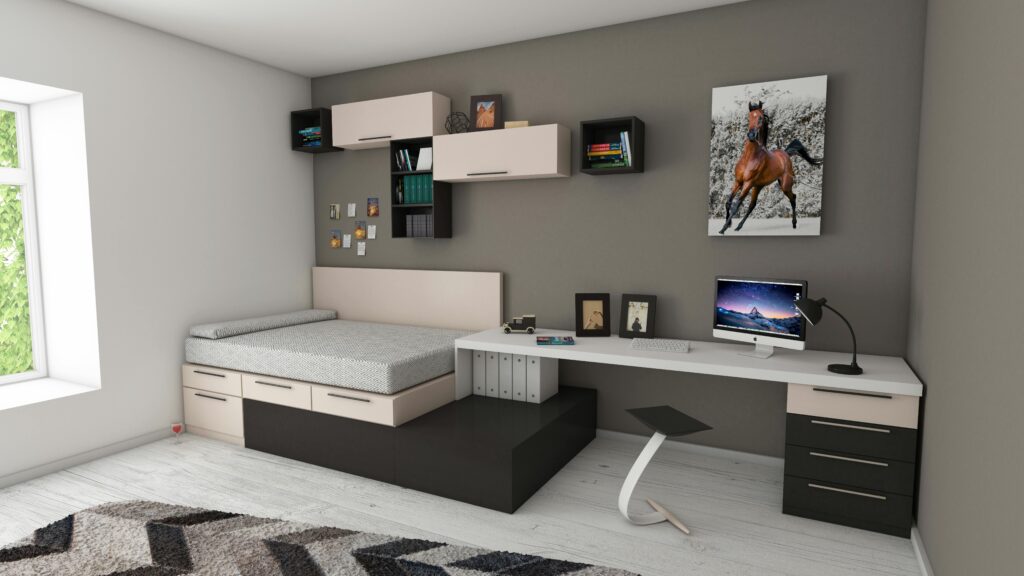 A modern kids’ bedroom with a built-in bed and desk, featuring shelves and a wall-mounted computer monitor.