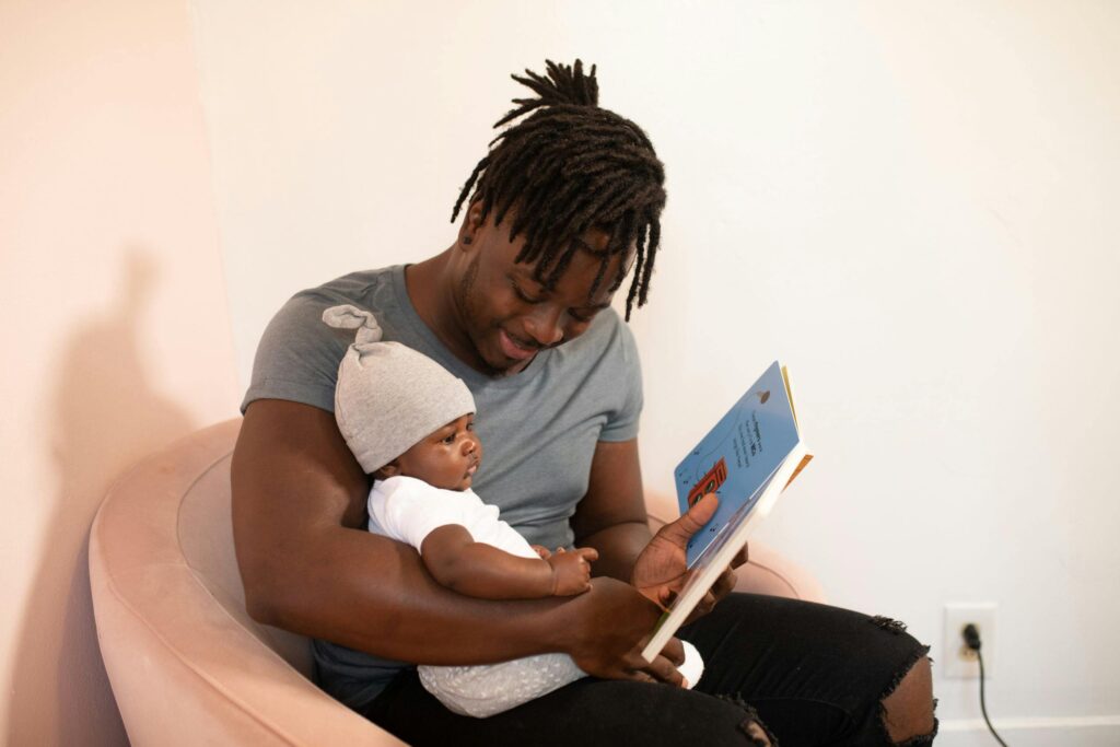A father reading a book to his baby, highlighting the bond created through shared reading experiences.
